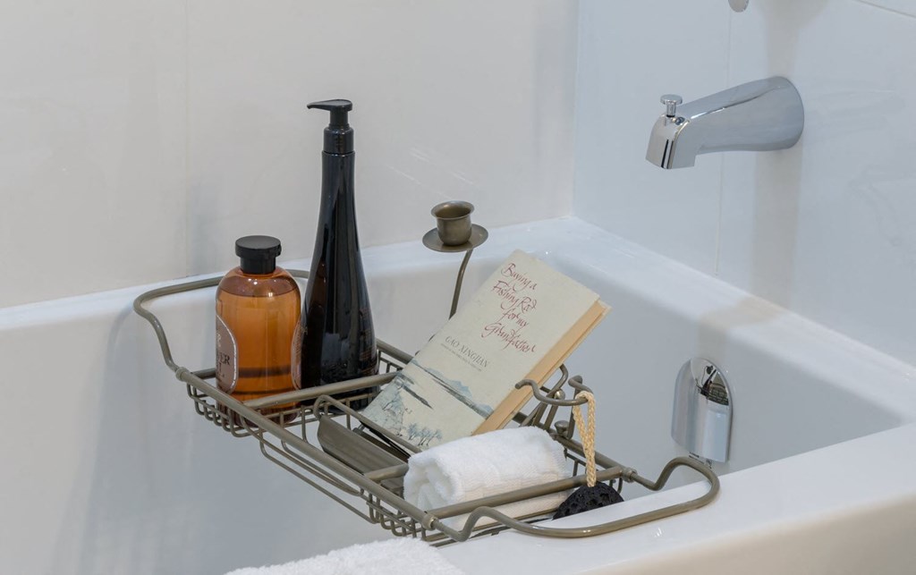 a rack with soap and a bottle in a bath tub