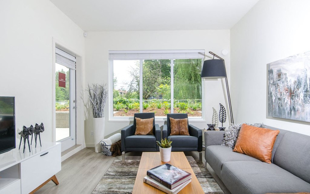 a living room with a couch and a coffee table and a large window