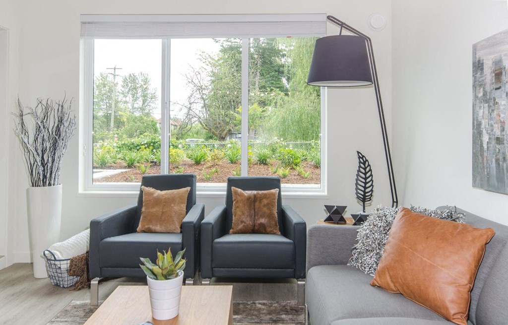 a living room with couches and chairs and a large window