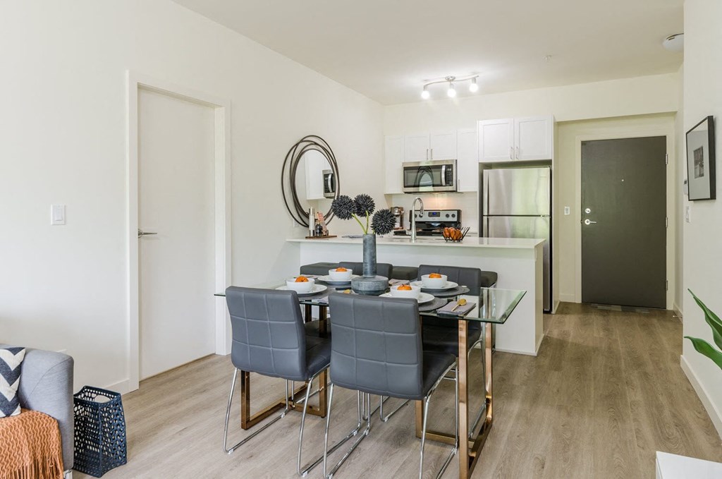 a dining room and kitchen with a table and chairs
