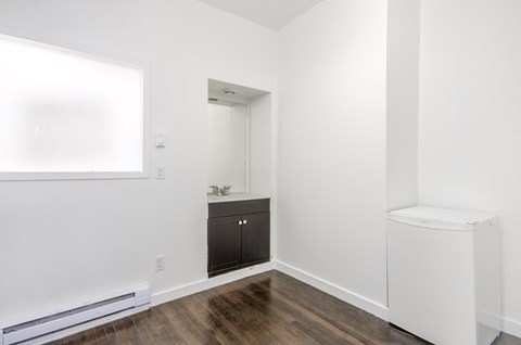 A white bathroom with a wooden floor and a white toilet.