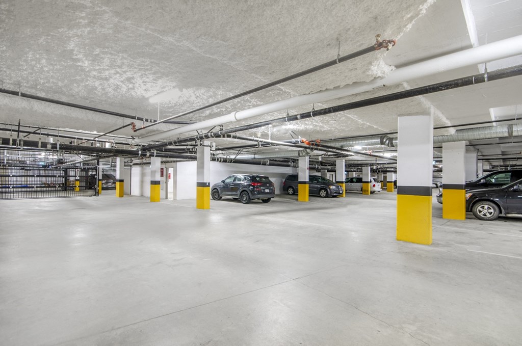 the underground parking garage of an apartment building with cars parked