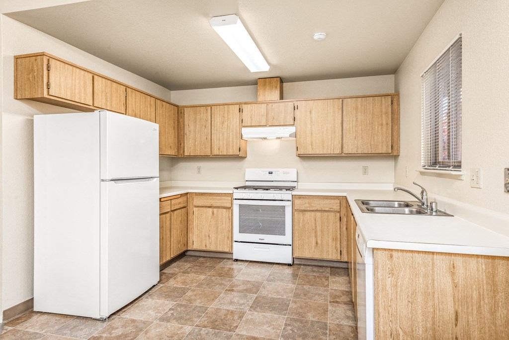Kitchen with white appliances and wooden cabinets at Meadowview Apartments, Santa Rosa, CA