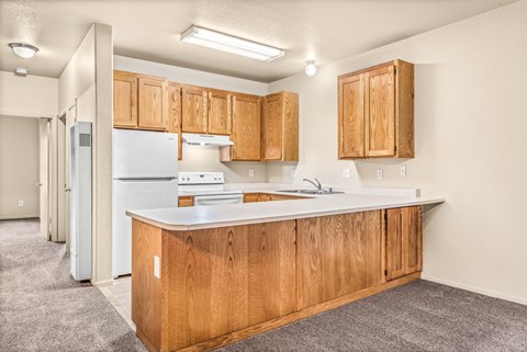 a kitchen with wood cabinets and a white counter top