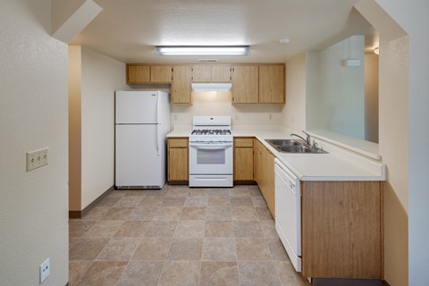 a kitchen with white appliances and wooden cabinets