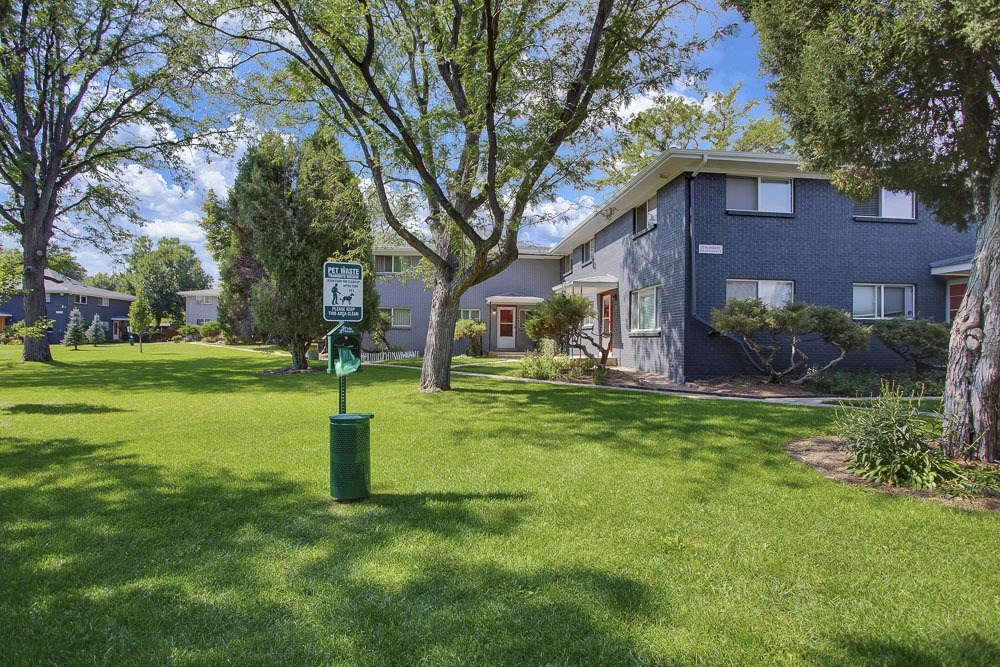 outdoor landscaping with apartment building in the back ground with a dog station