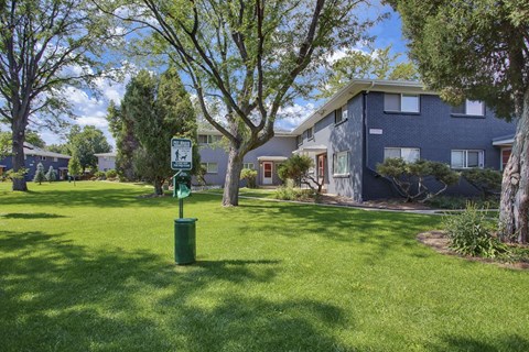 outdoor landscaping with apartment building in the back ground with a dog station