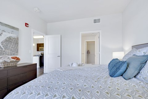 A bedroom with a large bed and a dresser.