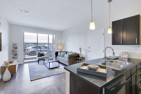 A modern kitchen with a large island and a view of the balcony.