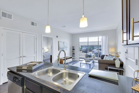 A modern kitchen with a large sink and a view of the city.