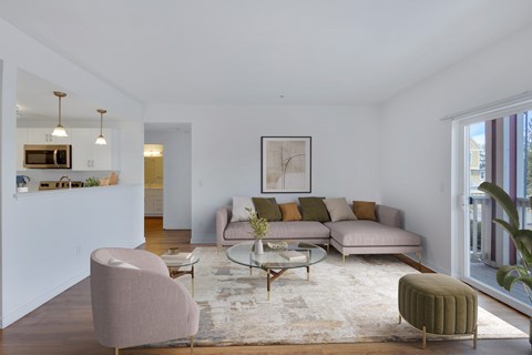 A living room with a grey sofa, a pink chair and a green ottoman.