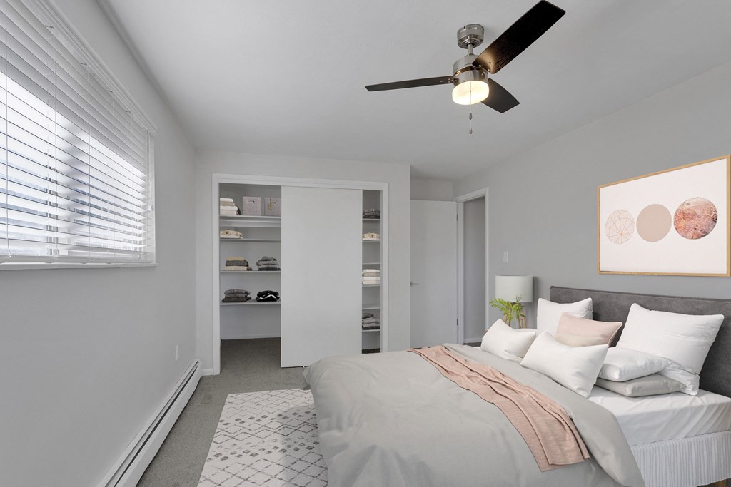 a bedroom with a large bed in the center with the view of a small closet in the back