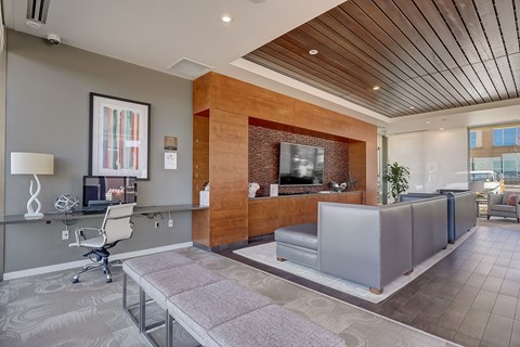 A modern living room with a wooden accent wall and a grey sofa.