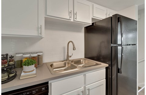 a kitchen with white cabinets and a stainless steel refrigerator