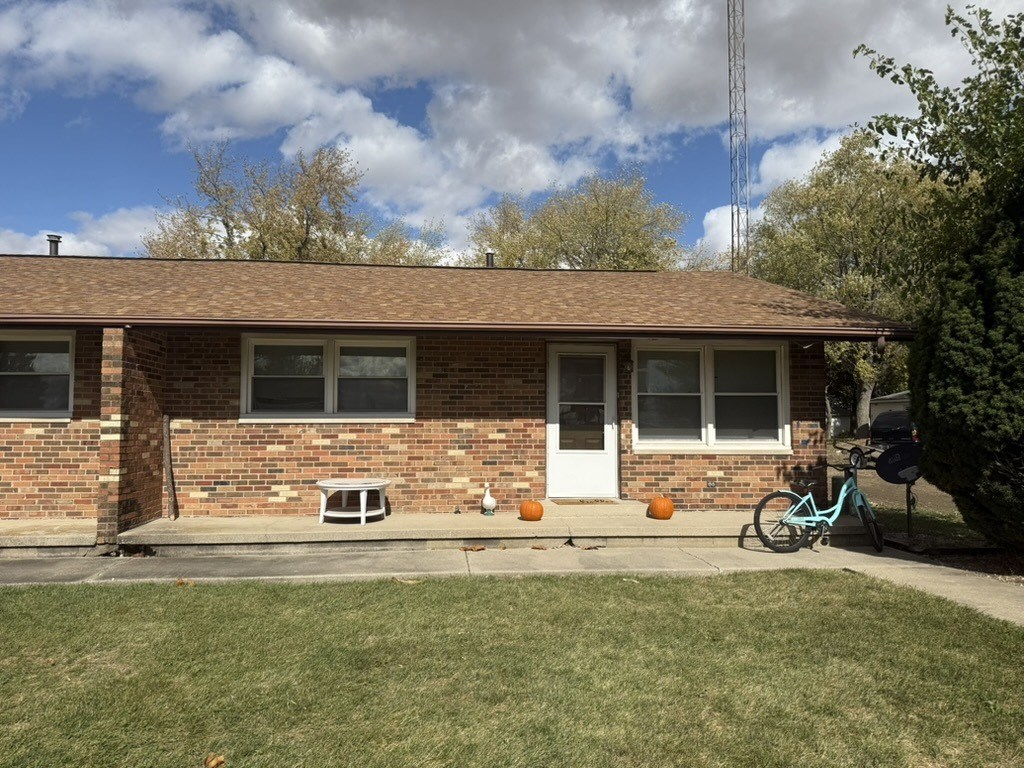 A house with a bicycle leaning against a tree.