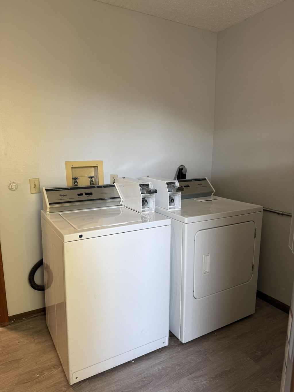 A white washing machine and dryer in a small room.