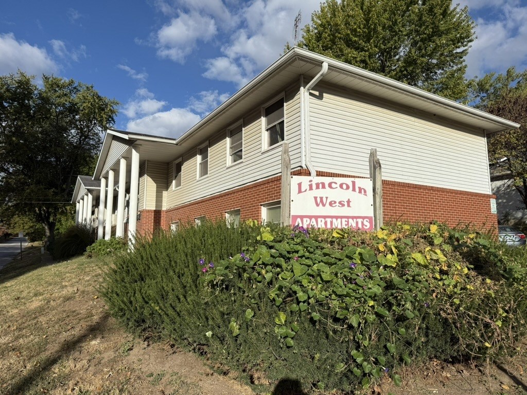 A building with a sign that says Lincoln West Apartments.
