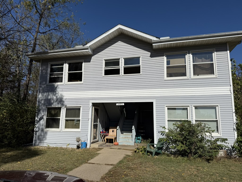 A house with a grey siding and a white roof.