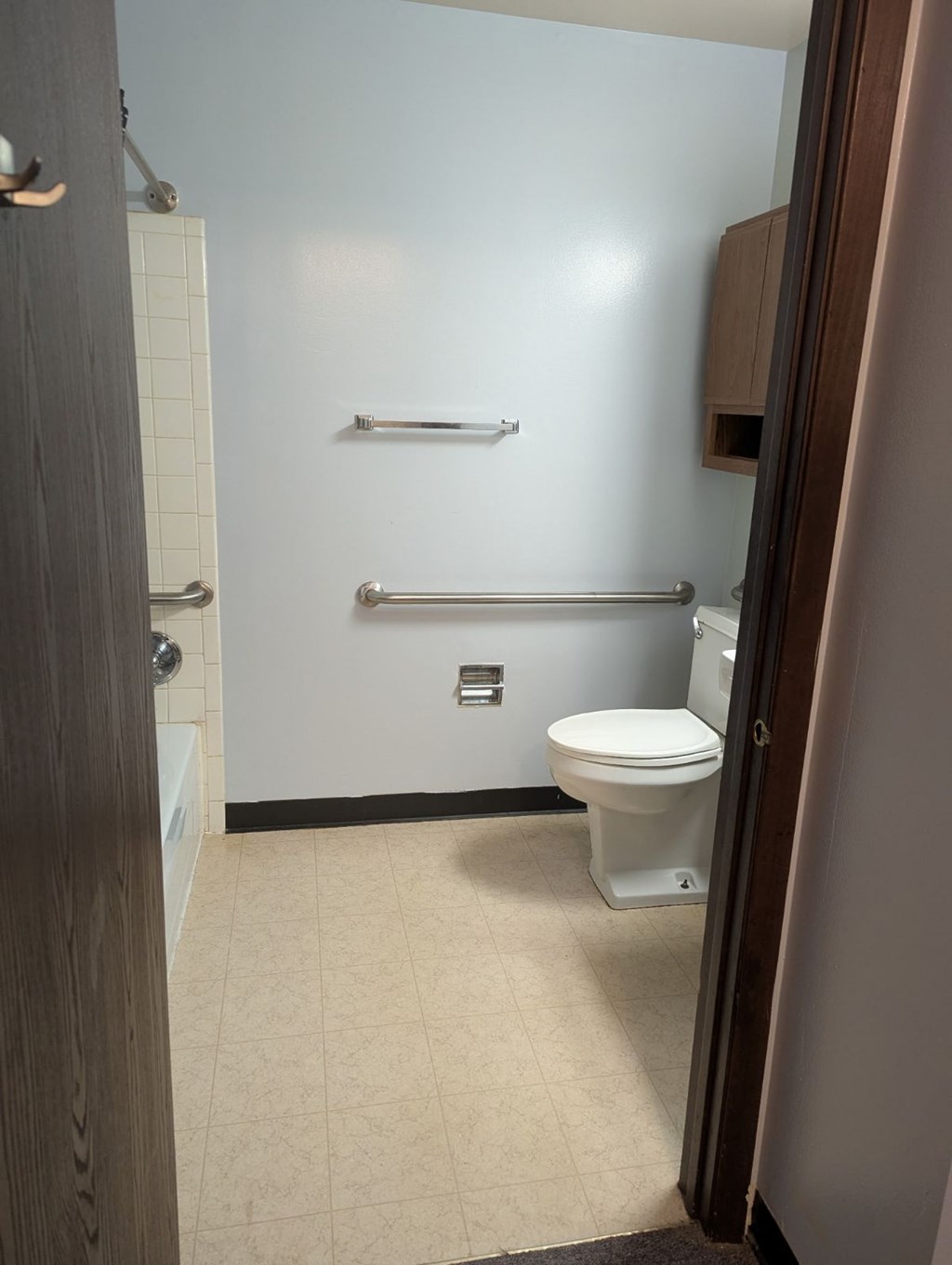 A white toilet in a small bathroom with a white door.