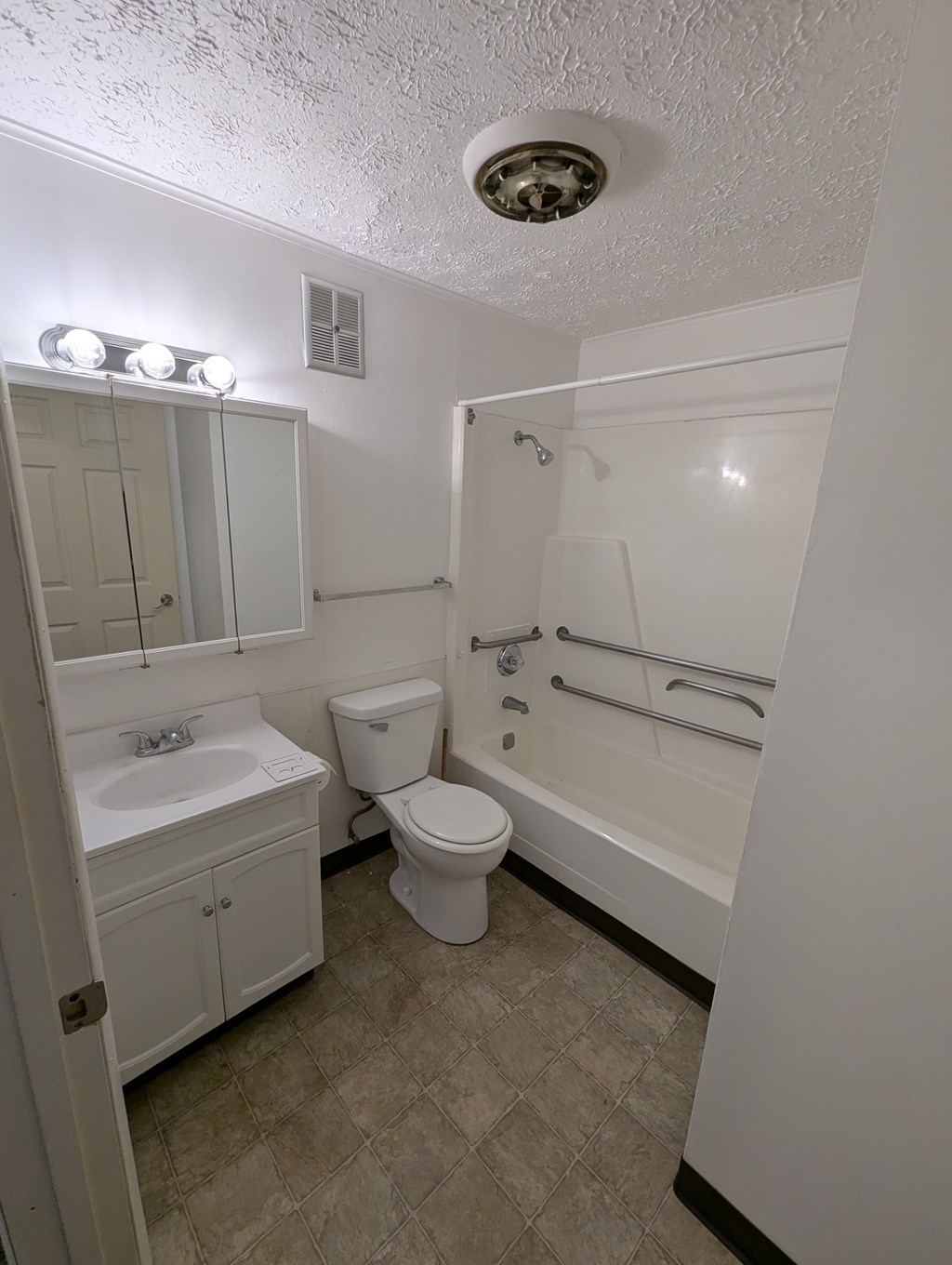 A white bathroom with a toilet, sink, and bathtub.