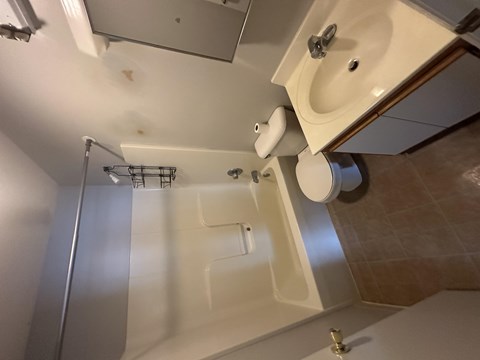 A white sink is mounted on a wall above a toilet.