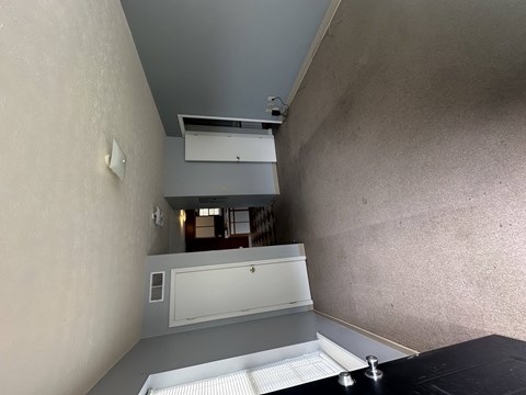 A room with a white door and a window with blinds.