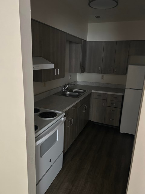 A kitchen with a white oven and sink.