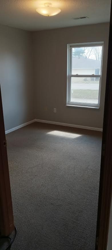 A room with a carpeted floor and a window.