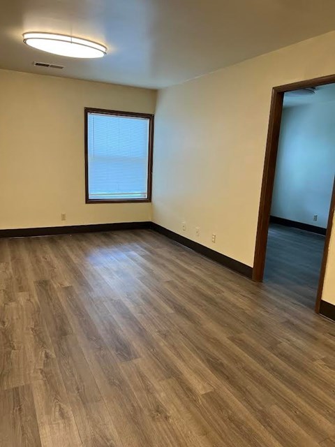 A room with wooden flooring and a window.