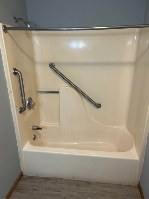 A white bathtub with silver fixtures in a bathroom.