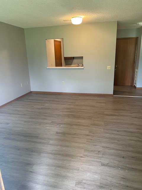 A room with wooden flooring and a mirror on the wall.