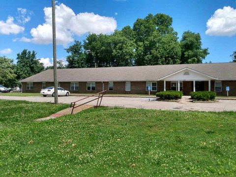 A building with a brown roof and a white car parked in front.