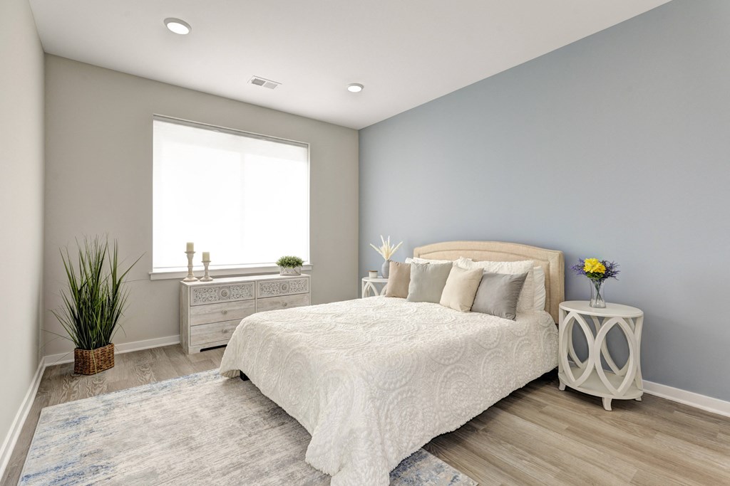 a bedroom with grey walls and a white bed
