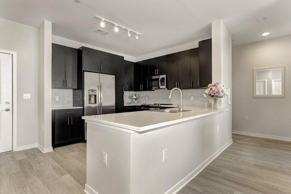 a kitchen with a large island and black cabinets