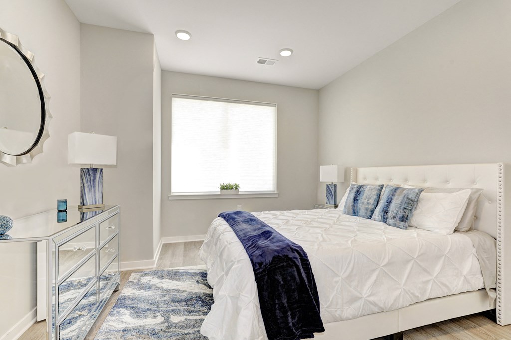 a bedroom with a bed and a dresser with a mirror