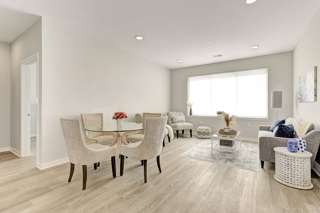 a living and dining room with hardwood floors and a large window