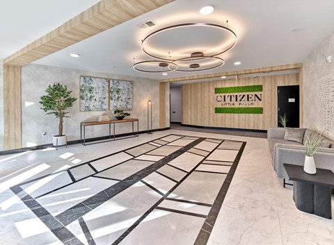 A modern lobby with a marble floor and a wooden ceiling.