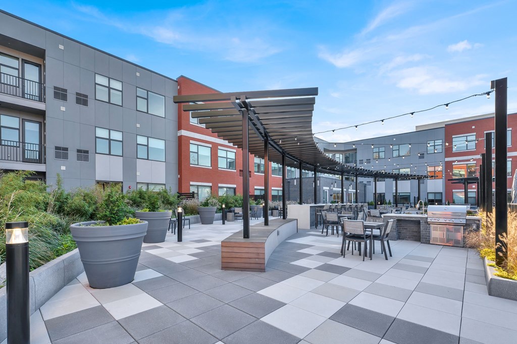 a patio area with tables and chairs and awnings