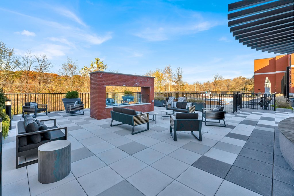 the patio of a building with chairs and a fire pit