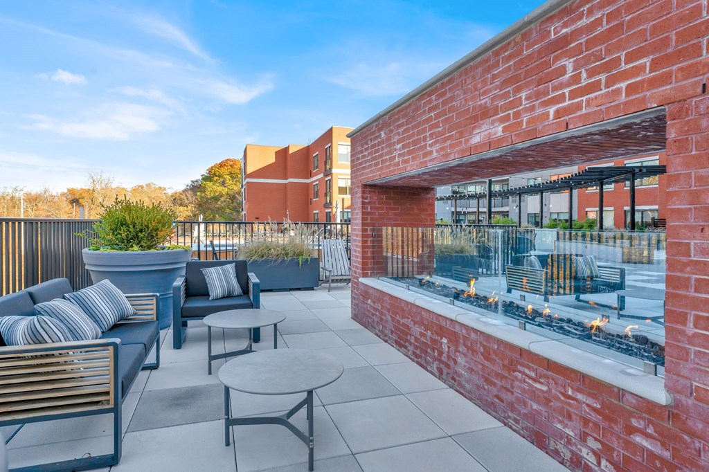 a patio with chairs and tables and a brick wall