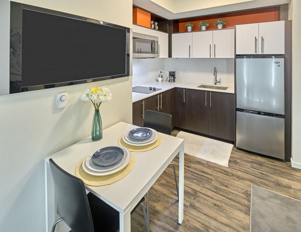 a kitchen with stainless steel appliances and a white table with chairs