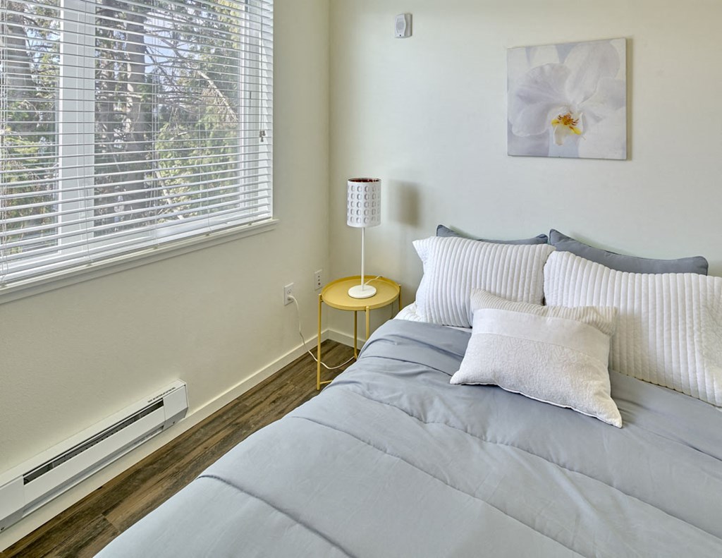 a bedroom with a bed and a large window
