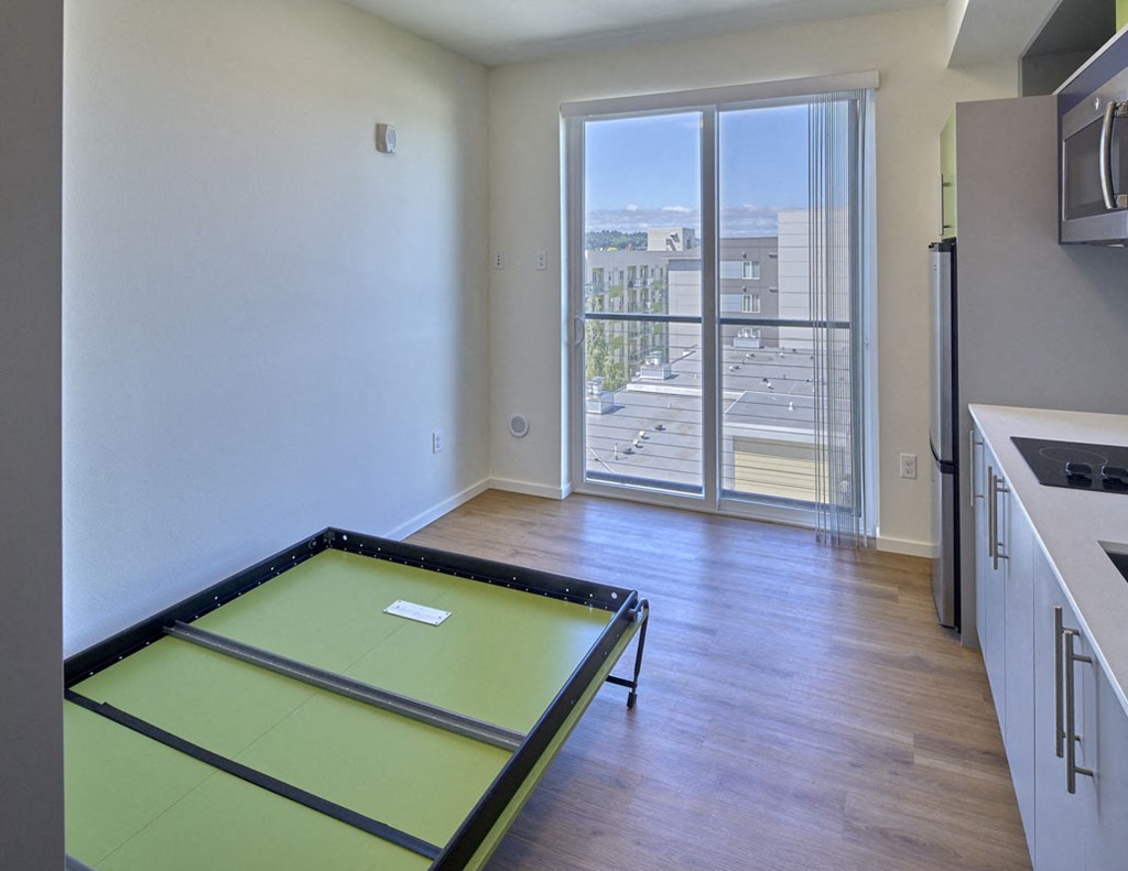 an empty living room with a pool table and a balcony