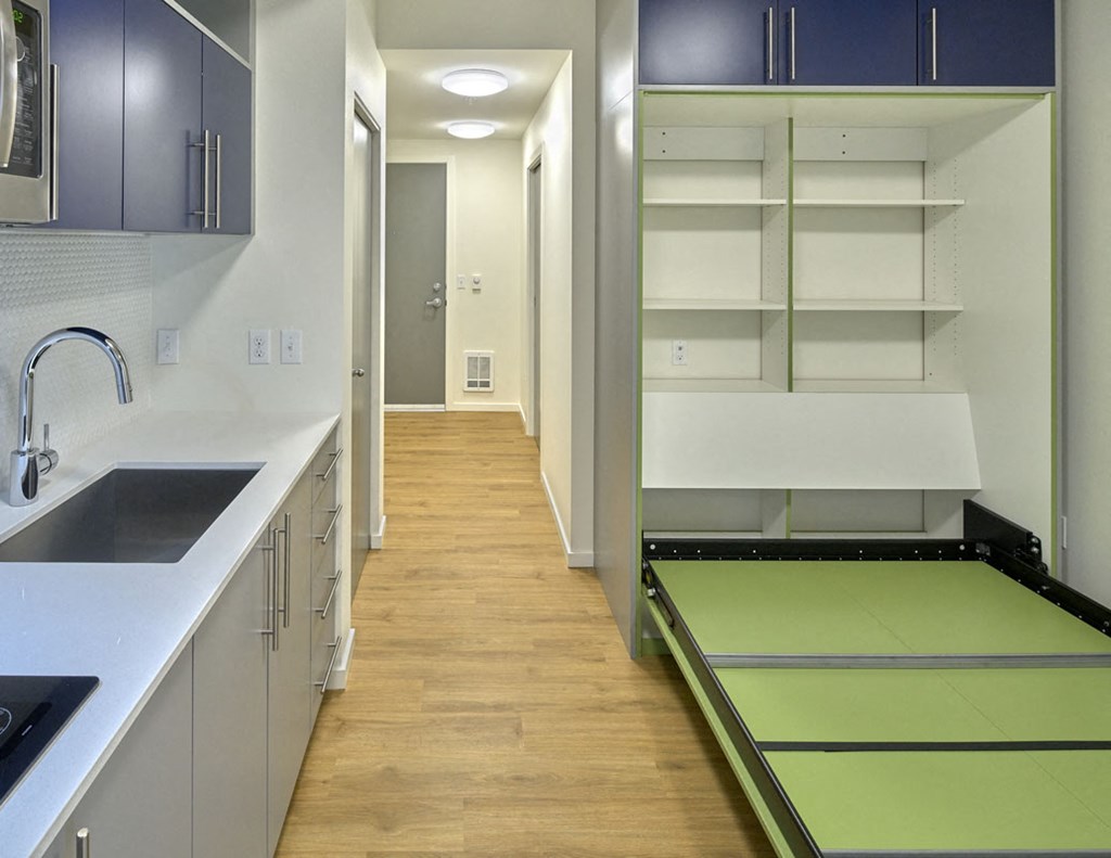 a long kitchen with a counter top and a sink