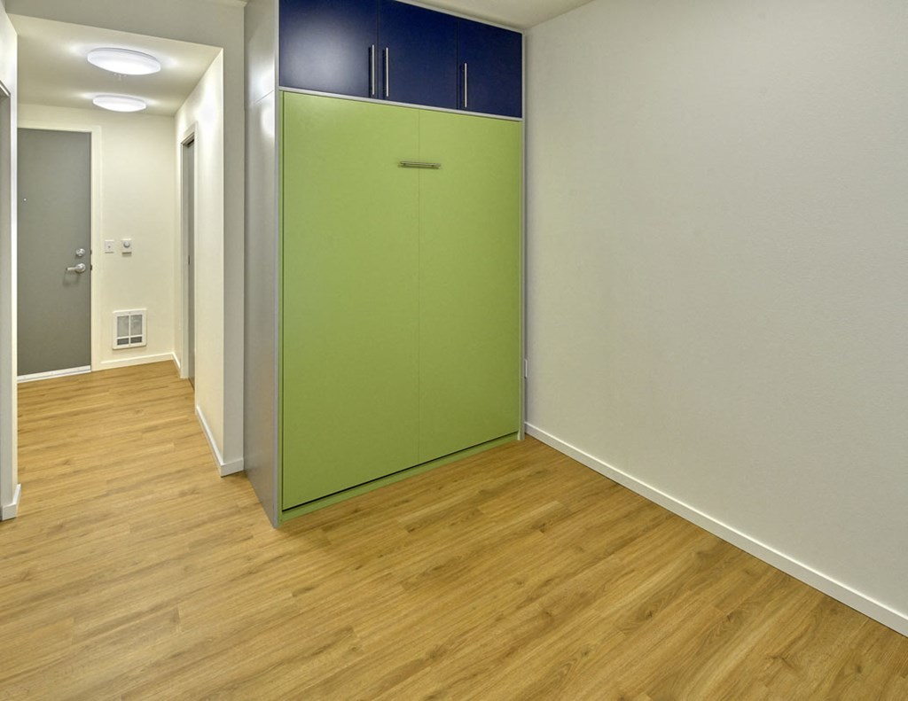 a green closet in a room with wood flooring