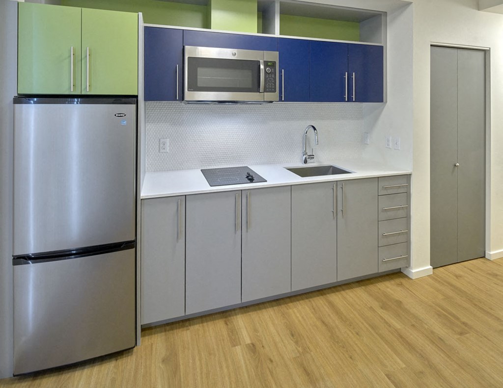 a kitchen with a sink and a refrigerator and a microwave