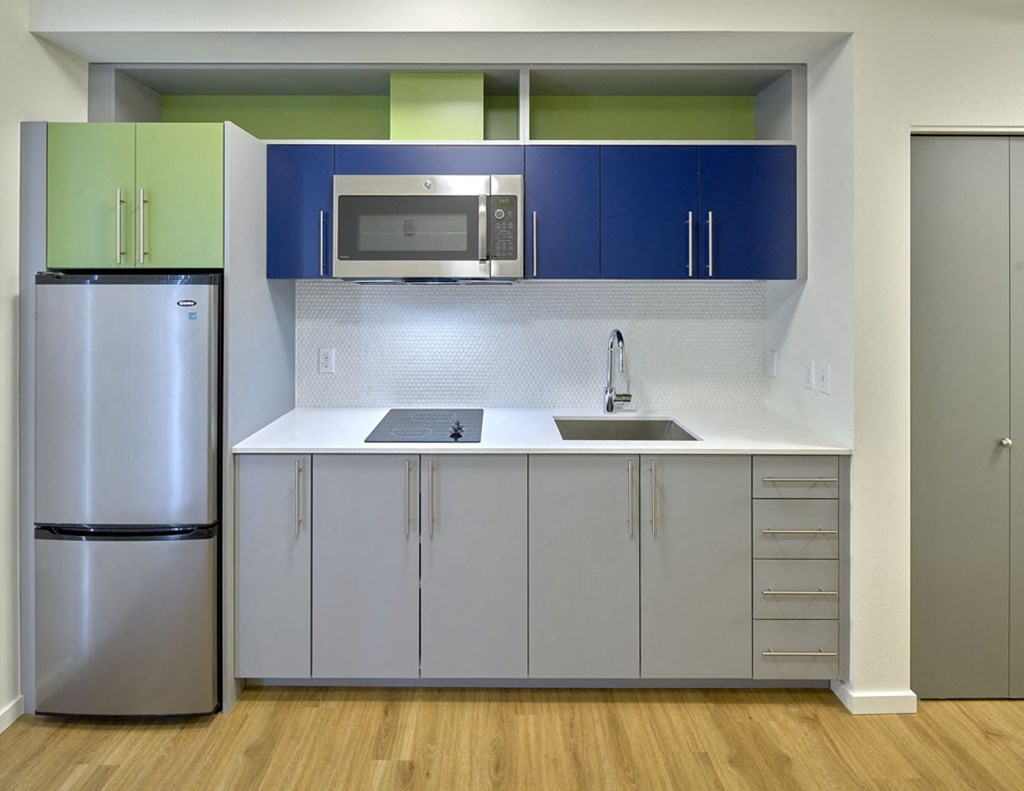 a kitchen with a sink and refrigerator and a microwave