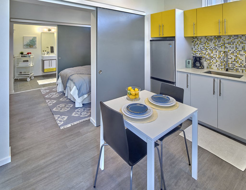 a kitchen and dining area with a table and chairs and a bedroom