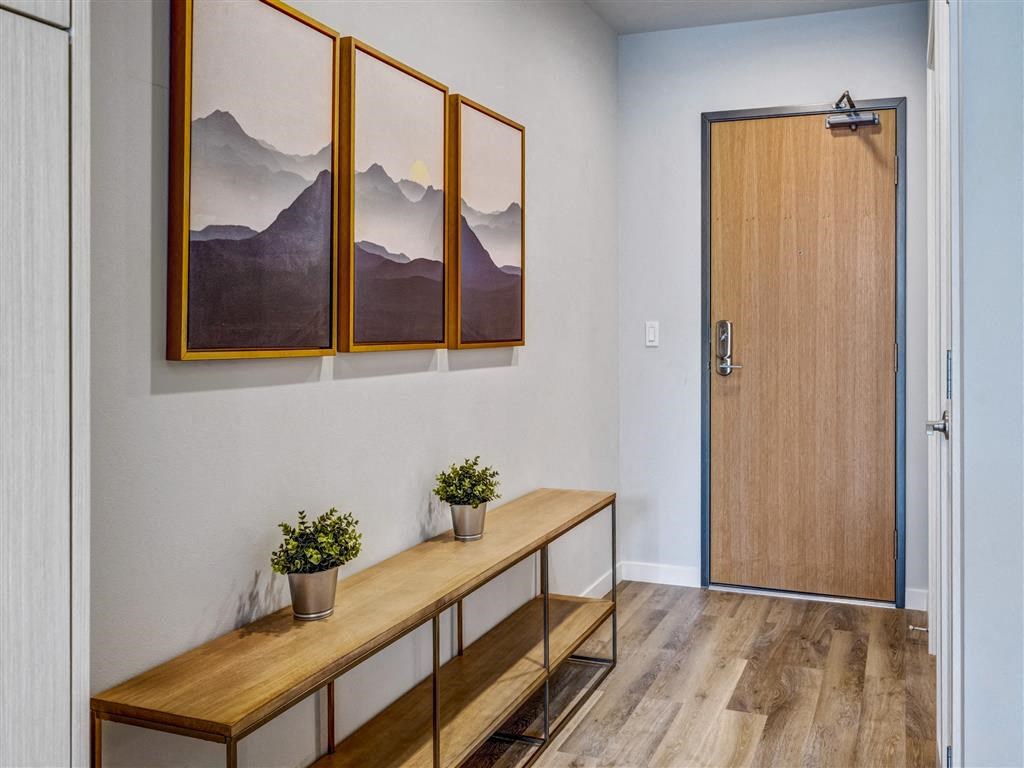 a hallway with a wooden door and paintings on the wall