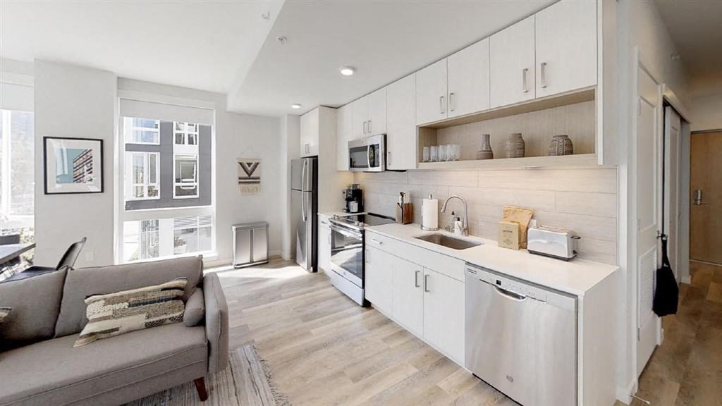 a kitchen and living room with a sink and refrigerator